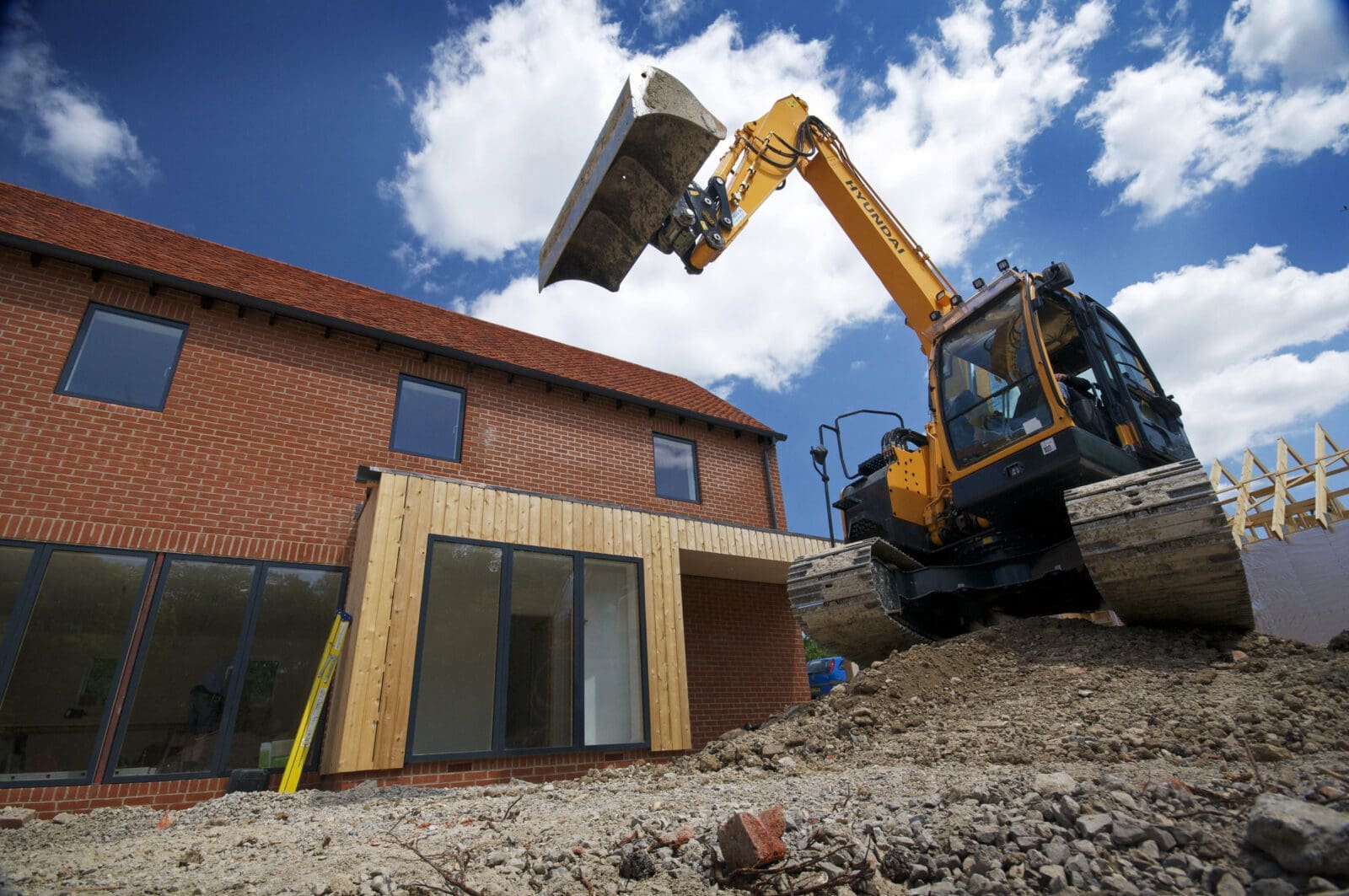 Digger in front of new build house
